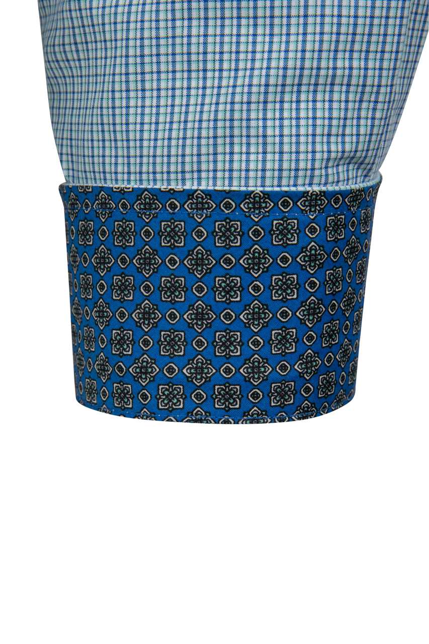 Close-up of a shirt cuff showing a blue and white gingham upper section and a folded cuff with a blue, black, and white geometric pattern.