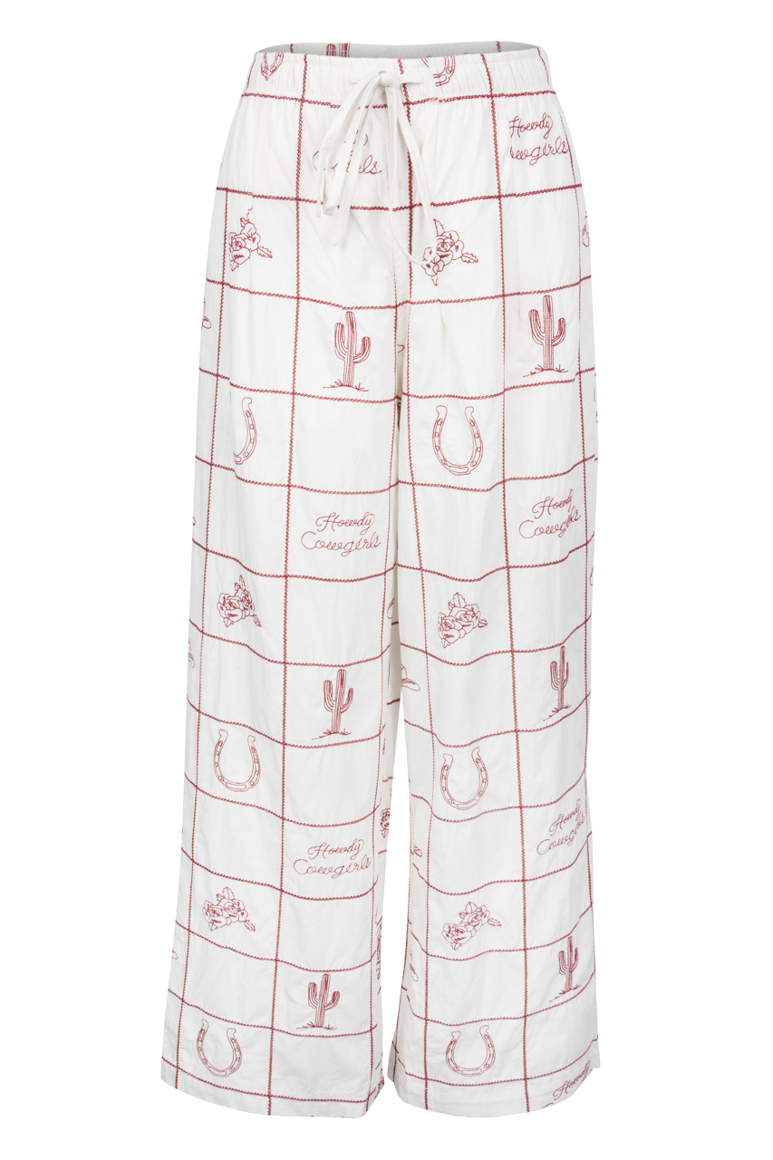 White wide-leg lounge pants with a red grid pattern and western-themed motifs including cacti, horseshoes, and the words 'Family Cowboys'.