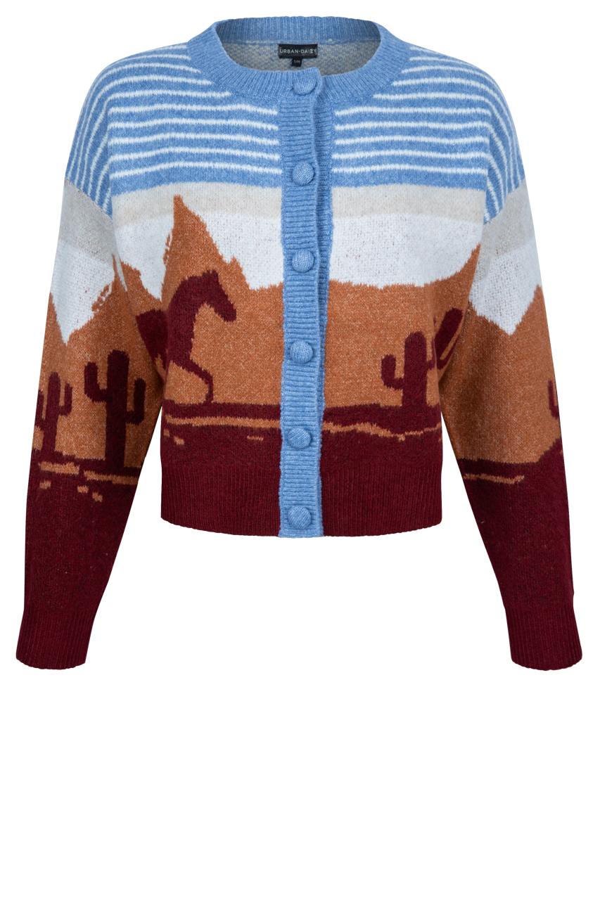 A cropped knit cardigan sweater featuring a desert landscape pattern with mountains, cacti, and a horse, in shades of blue, brown, burgundy, and white.