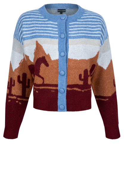 A cropped knit cardigan sweater featuring a desert landscape pattern with mountains, cacti, and a horse, in shades of blue, brown, burgundy, and white.