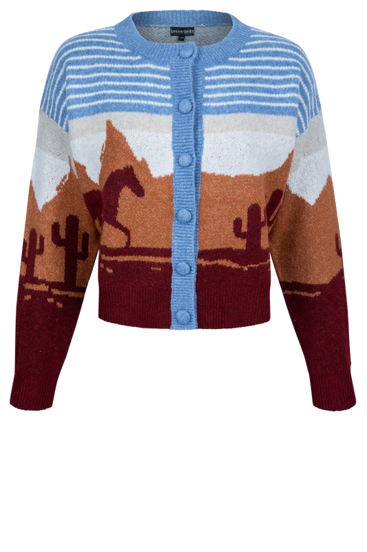 A cropped knit cardigan sweater featuring a desert landscape pattern with mountains, cacti, and a horse, in shades of blue, brown, burgundy, and white.