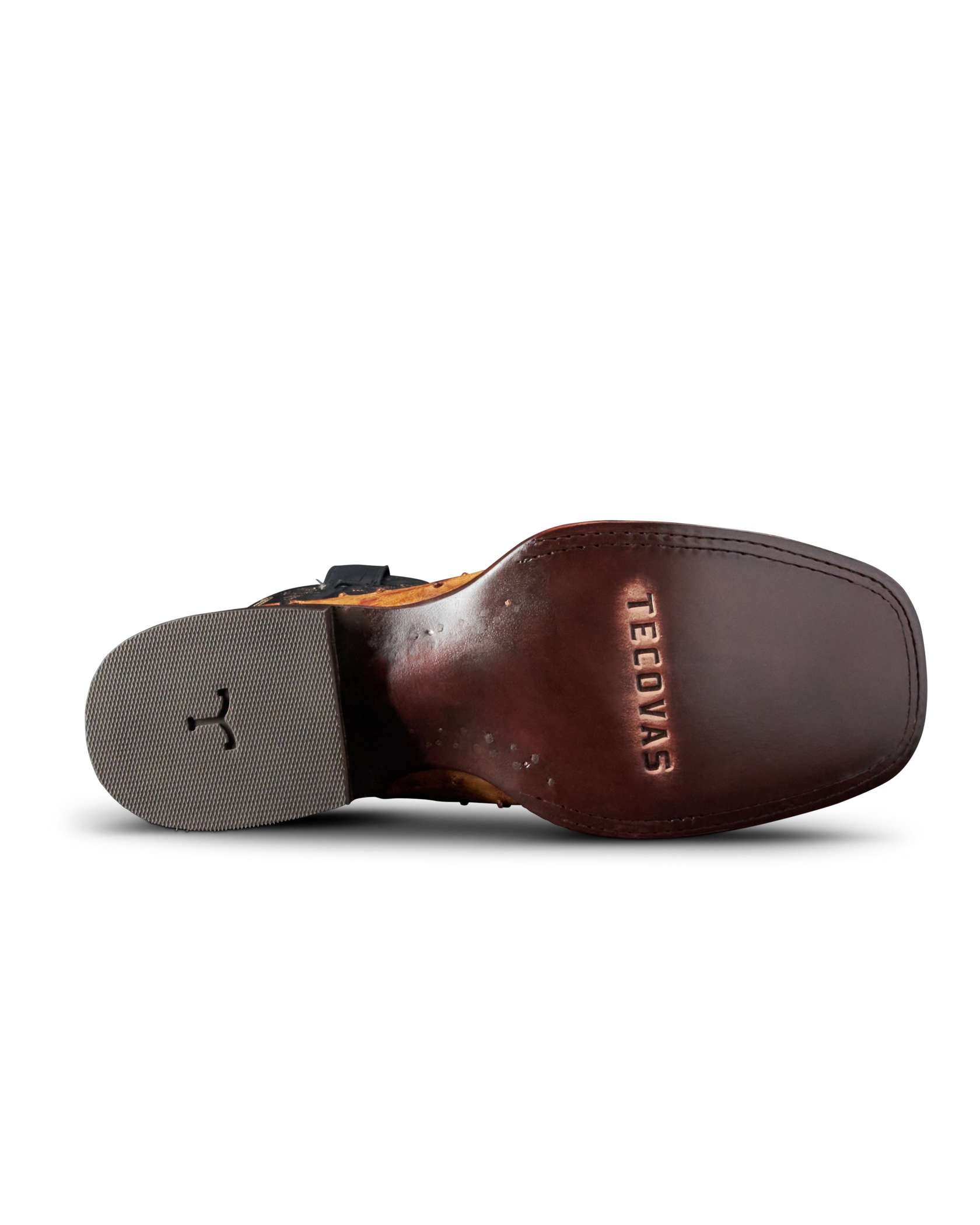 A close-up bottom view of a brown leather boot sole, showing the embossed brand name 'TEEDYAS' on the heel bed and a gray outsole with a black logo.