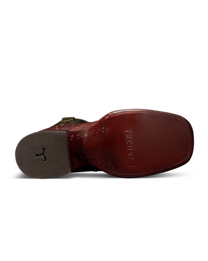 The bottom sole view of a brown leather boot by Tecnovas, showing the embossed brand name on the footbed and a textured gray heel.