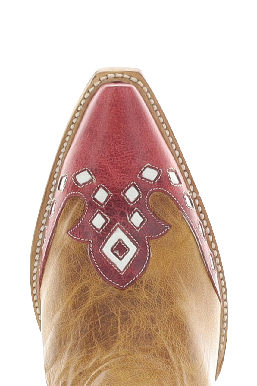 Close-up of a cowboy boot toe featuring a pointed red leather tip with white geometric cutout details over a tan leather shaft.