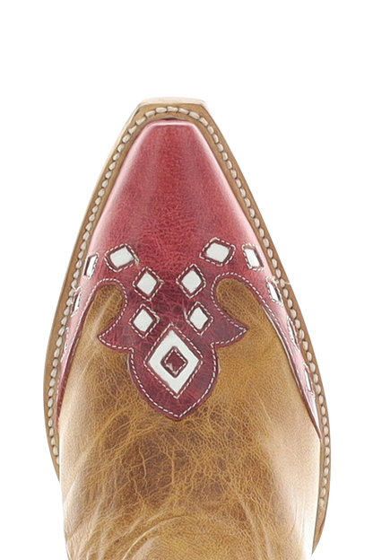 Close-up of a cowboy boot toe featuring a pointed red leather tip with white geometric cutout details over a tan leather shaft.