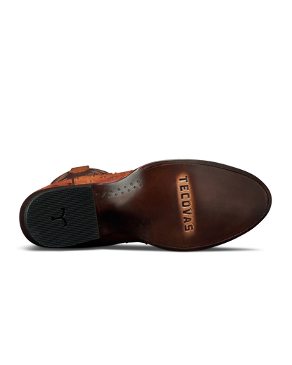 The outsole of a brown leather boot by Teecovas, showing the brand name embossed on the heel area and a black rubber heel block.